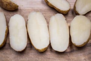 البطاطس المخبوزة مقطعة إلى نصفين وجاهزة للتقطيع قبل الحشو.