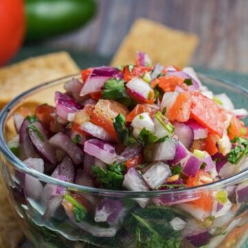 wide sideview image of pico de gallo with chips and fresh vegetables.