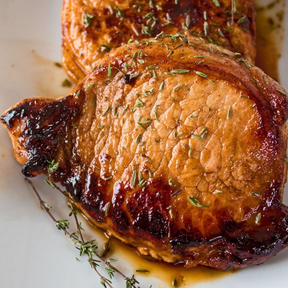 Immagine quadrata di braciole di maiale glassate al balsamico.