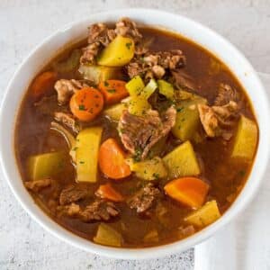 Overhead image of white bowl of beef stew.