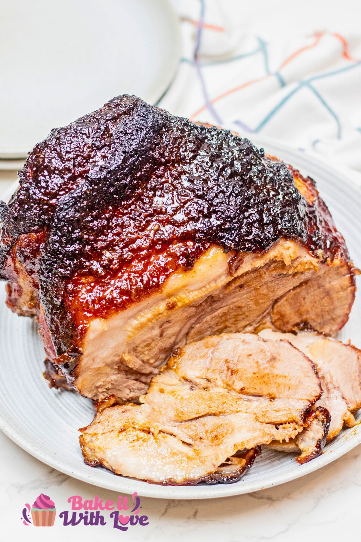 A tall image showing Brown sugar and Dijon-crusted pork roast sliced on a plate.