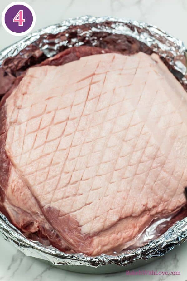 Brown sugar dijon pork roast process photo 4 showing the raw, unglazed pork roast in a foil-lined roasting pan.
