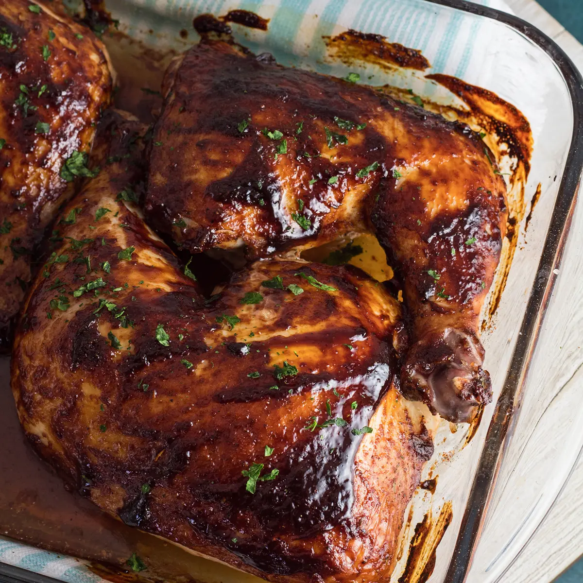 large square overhead of the baked bbq chicken quarters in the pan and ready to serve.