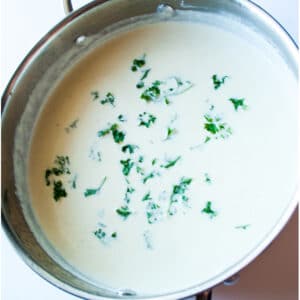 Square image of homemade alfredo sauce in a skillet.