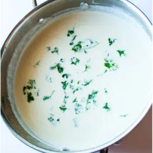 Square image of homemade alfredo sauce in a skillet.