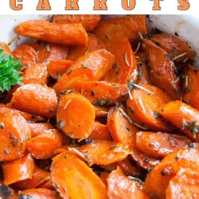 Pin image with text of roasted honey glazed carrots in a white baking dish.