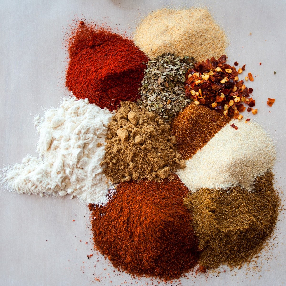 Homemade chili seasoning mix spices on a white background.