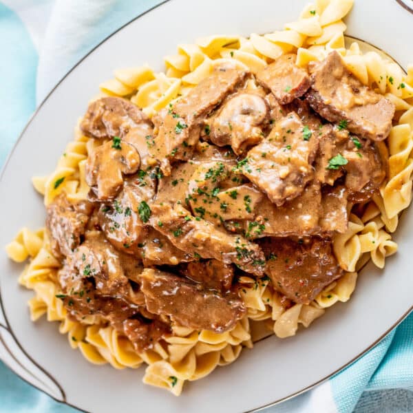 Leftover prime rib beef stroganoff plated on silver rimmed serving platter.