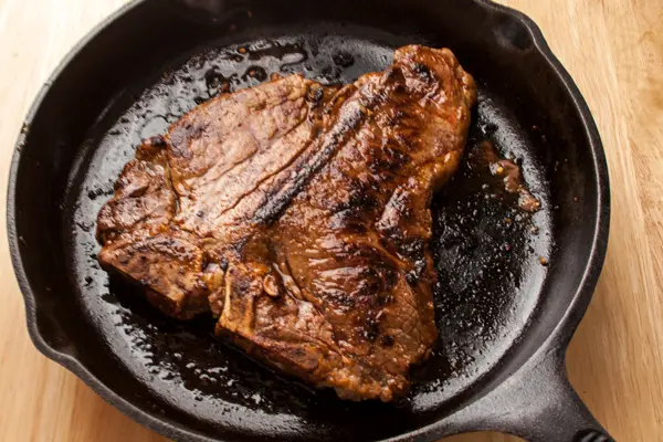 Pan Seared Red Miso Porterhouse Steak shown in the cast iron skillet it was cooked in, www.bakeitwithlove.com