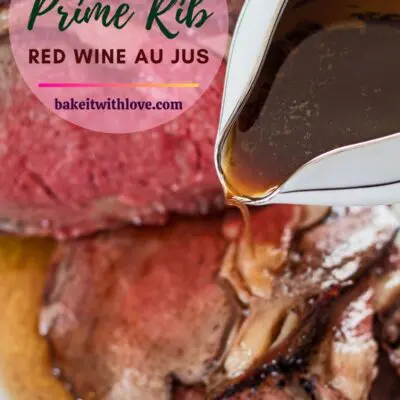 vertical pin with prime rib red wine au juse being poured over rib roast.