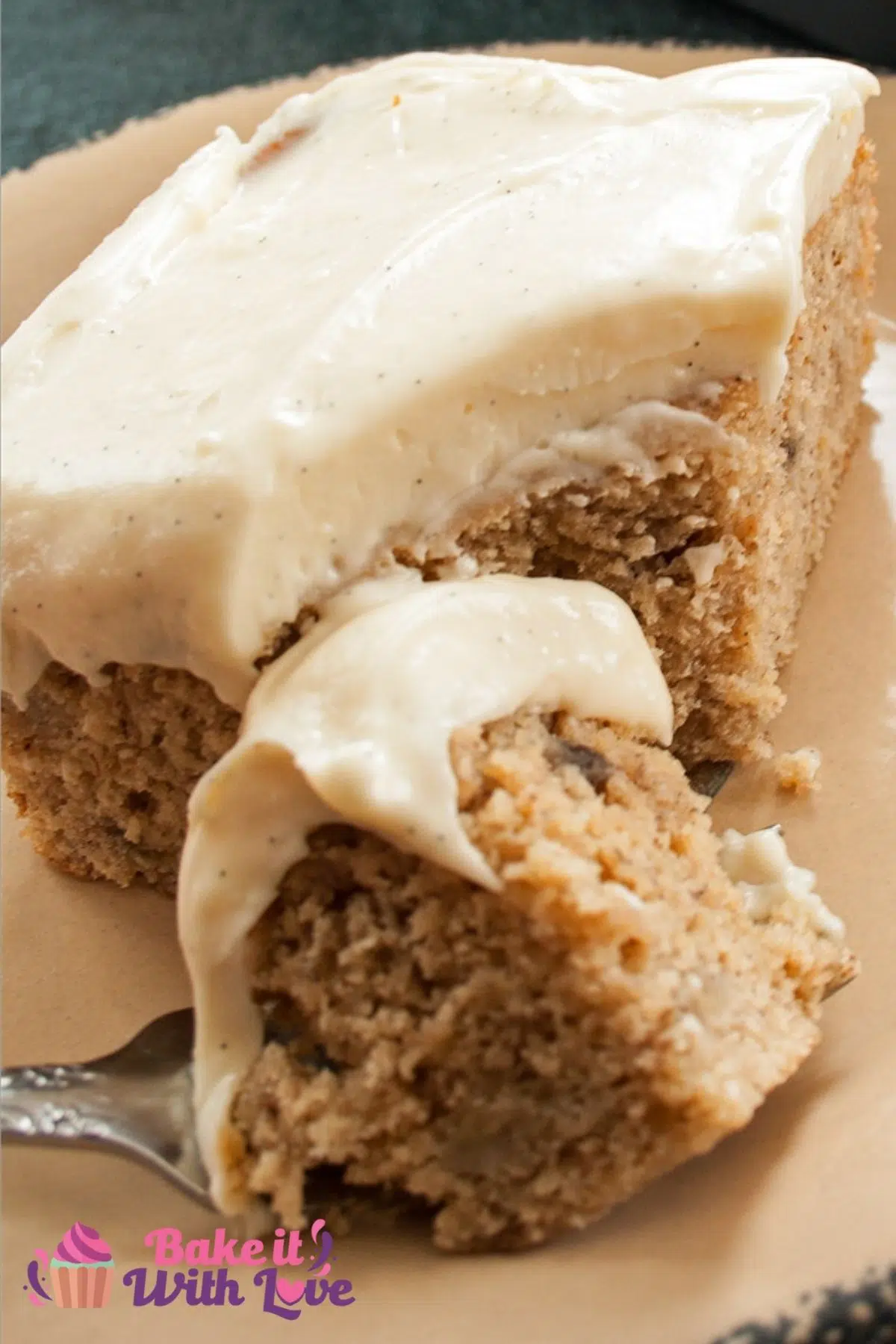 Closeup on the super moist banana cake with cream cheese frosting slice with forked bite.