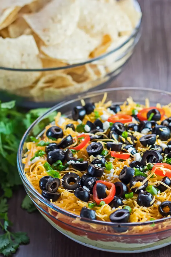 tall angled overhead of 7 Layer Dip with chips in background.