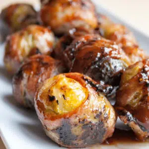 Best bbq bacon wrapped brussel sprouts served on white platter.