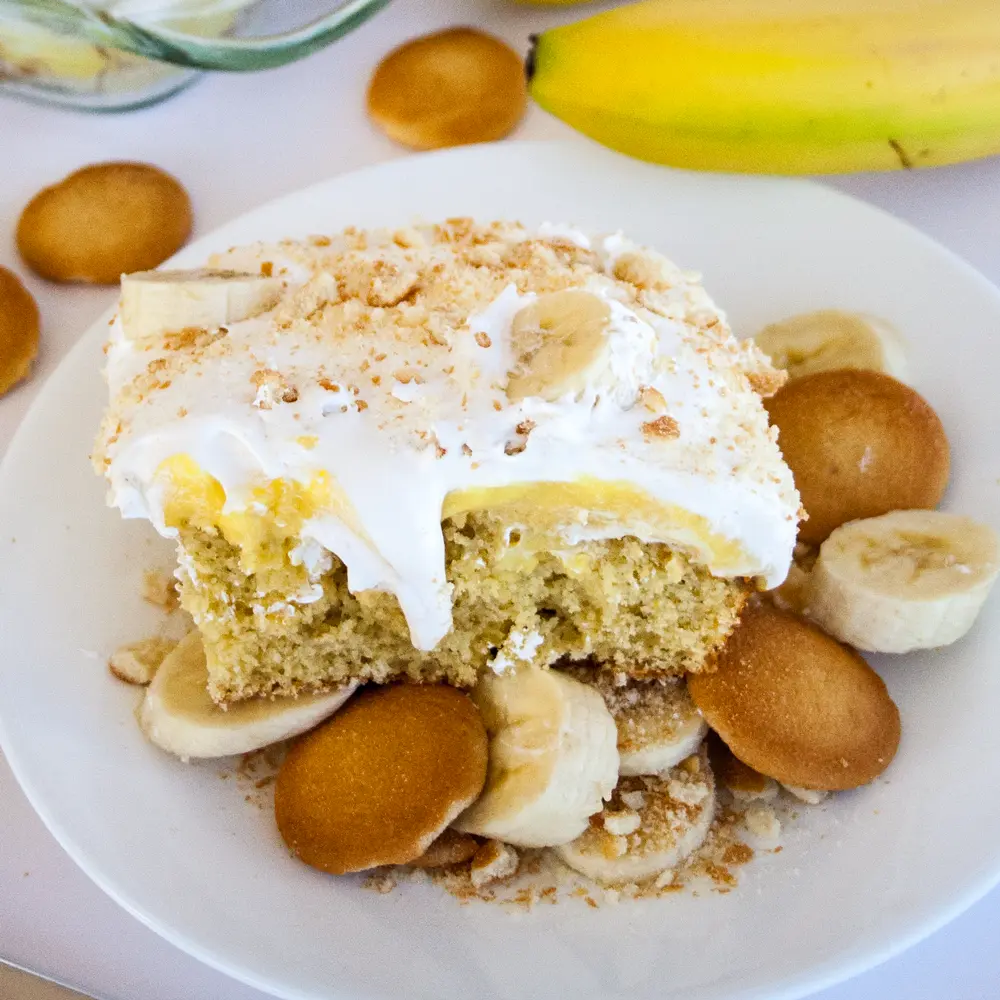 Banana Pudding Poke Cake on a plate with nilla wafers.