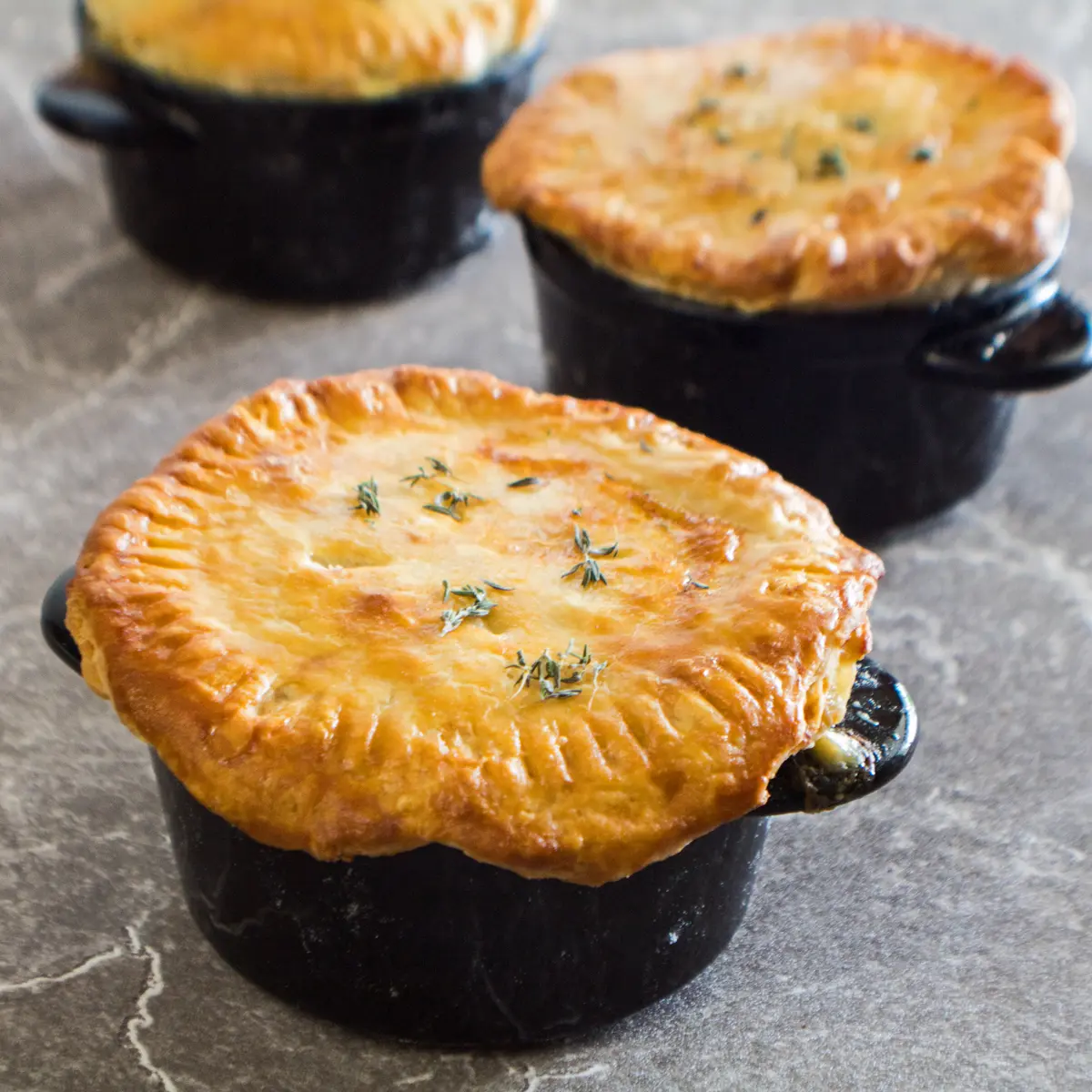 Individual pot pies in ramekins, collection of three pot pies ready to eat.