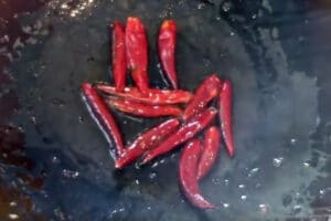 browning the whole dried chili peppers in the wok oil after stir frying the vegetables