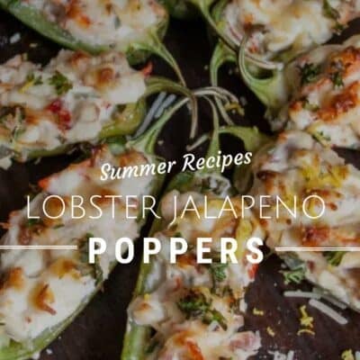 Overhead view of lobster jalapeño poppers arranged on a dark baking tray. The halved jalapeños are filled with a creamy lobster and cheese mixture, topped with melted golden-brown cheese, chopped herbs, and shredded Parmesan. White text over the image reads "Summer Recipes – Lobster Jalapeño Poppers" with a note at the bottom: "For full recipes visit BakeItWithLove.com".