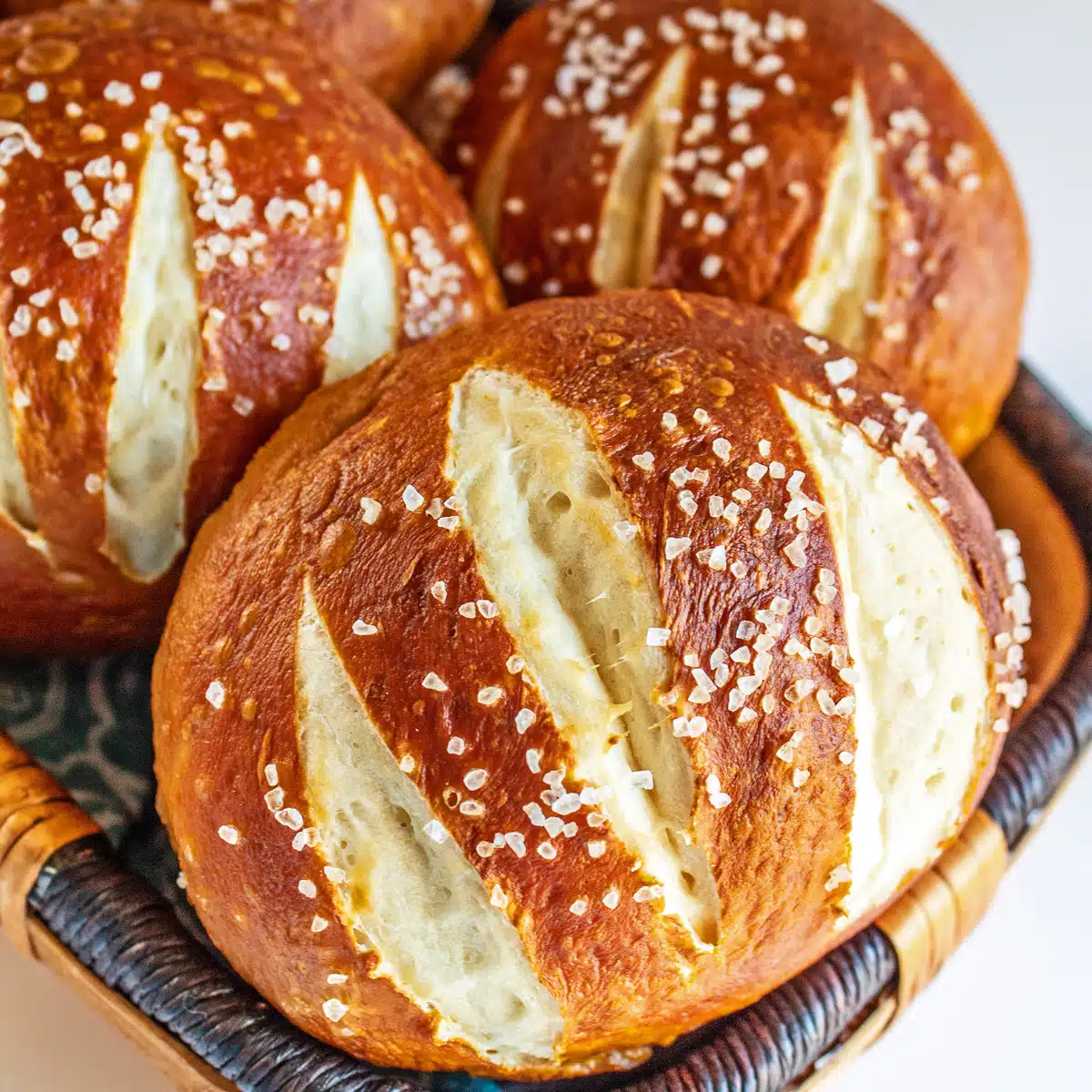 Best pretzel buns recipe for perfect homemade burger buns shown in basket.