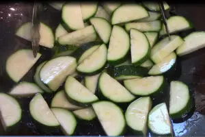 sliced zucchini cooking after the chicken but before the mushrooms, garlic, ginger and sauce is added