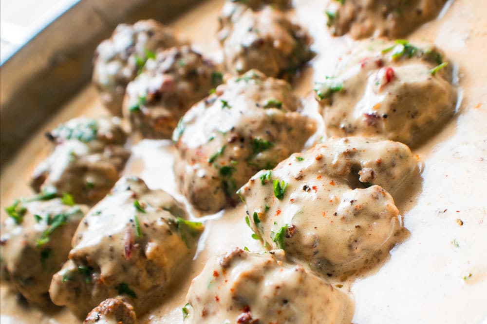 Swedish Meatballs (Svenska Köttbullar with Lingonberries) cooking in the Swedish meatball gravy.