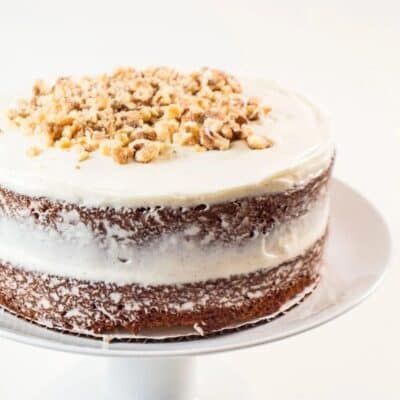 Square image of carrot cake with cream cheese frosting.