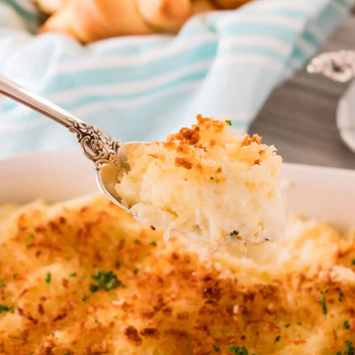 Parmesan roasted mashed potatoes being scooped up with a large spoon.