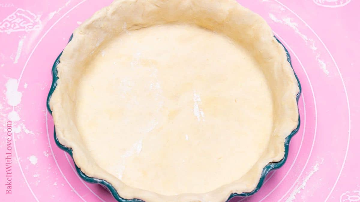 A wide horizontal image showing homemade all-butter pie crust dough that had been rolled out and pressed into a pie dish.