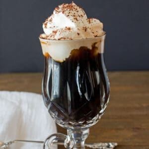 Heerlijke, zachte Irish Coffee is een hete koffiecocktail die bedoeld is om door de schuimige roomtopping te nippen.