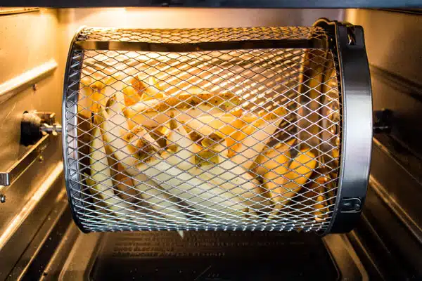 Freshly cut fries in the air fryer rotisserie basket of an Instant Pot Vortex Plus air fryer.
