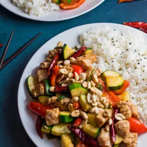 large square image of Panda Express Kung Pao Chicken served on a white plate with rice on a blue background