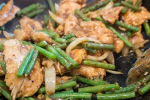 panda express copycat recipe of string bean chicken breast being stir fried in the wok with sauce before serving