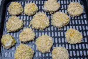 panko breaded pickle chips spaced apart on the non stick spray coated air fryer tray