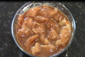 sliced chicken breast coated with sauce ingredients and cornstarch to marinate