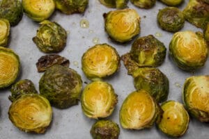 oven roasted brussel sprouts, crispy and caramelized, as shown here on the baking sheet when cooked and removed from the oven
