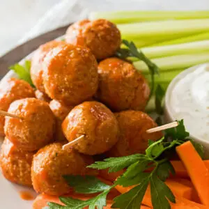 close up image of leftover buffalo turkey meatballs served on a tray with carrots, celery, and ranch dressing