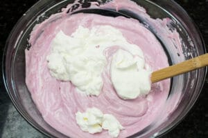 folding in the first portion of whipped cream to the blackberry puree base to make the blackberry cream pie filling