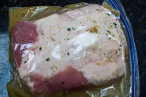 pork loin roast sealed in gallon size plastic storage bag with apple cider marinade for pork