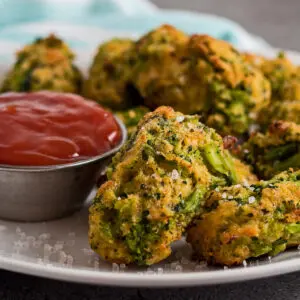 large square image of easy to make healthy baked broccoli tots served on a white plate with a side of ketchup