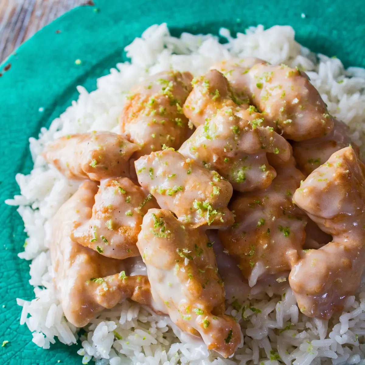 Large square overhead angle of the chicken served with rice on green plate.