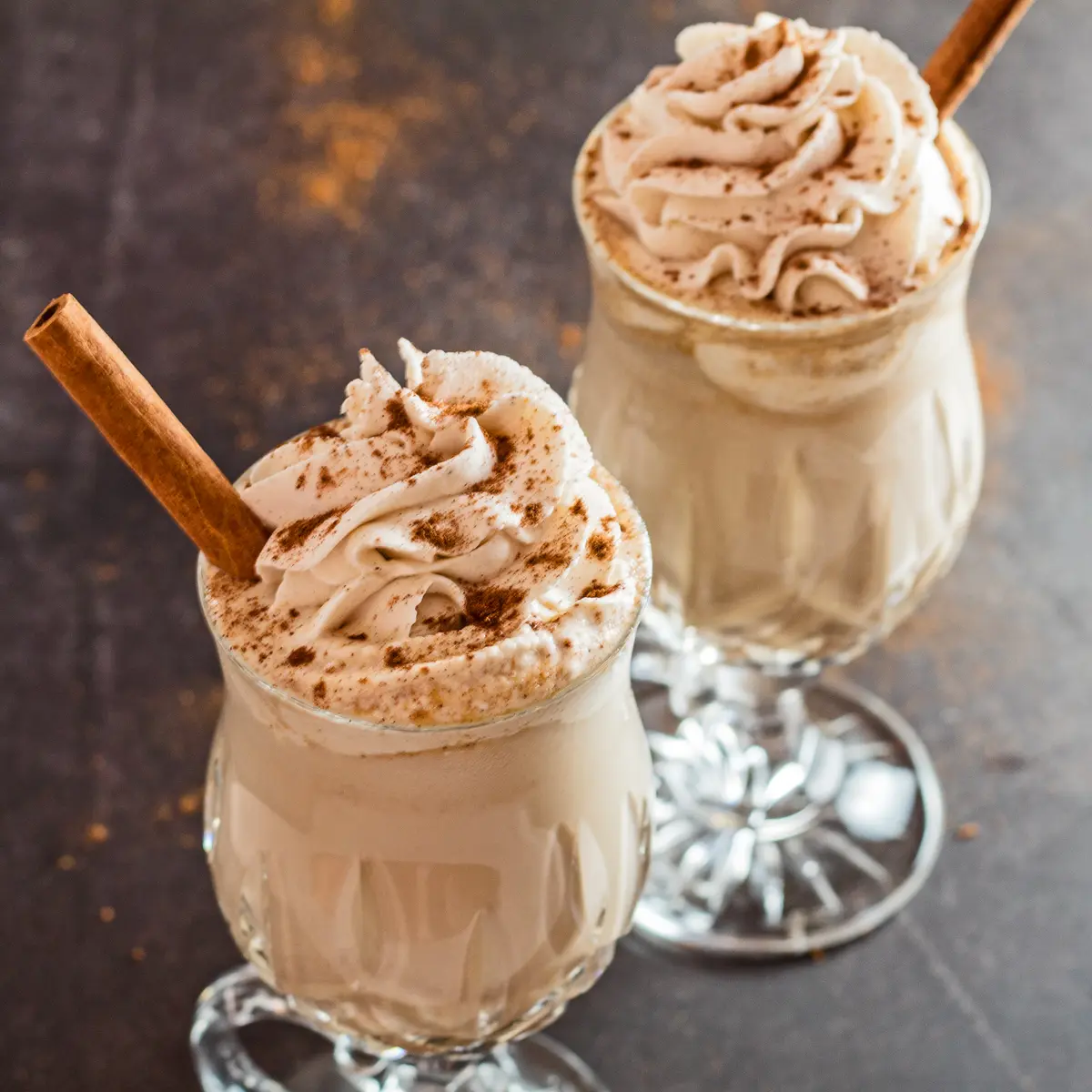 Large angled overhead of iced pumpkin spice latte topped with whipped cream.