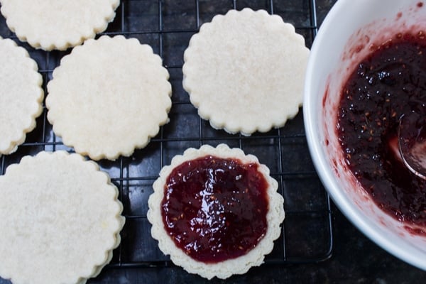 filling the shortbread cookies with raspberry or strawberry jam or preserves