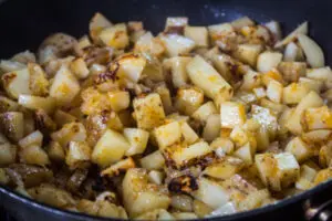 pan fried potatoes after cooking with a cover on and being turned to finish frying.