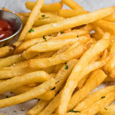 wide image of air fryer frozen french fries served with ketchup.