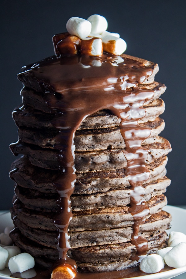 tall side view image of the stacked chocolate pancakes on dark background.