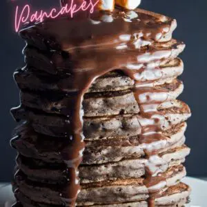 pin with tall image of stacked chocolate pancakes on dark background.