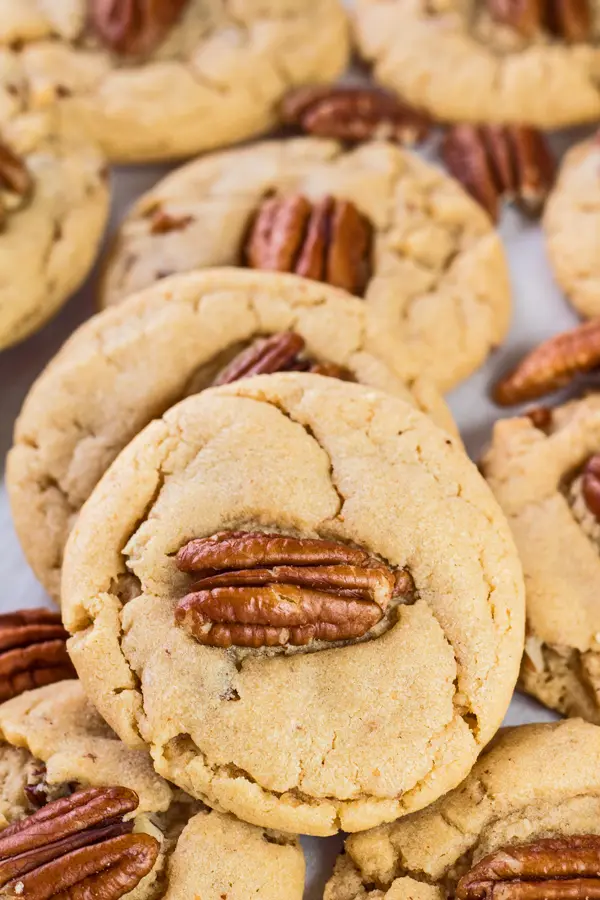 tall overhead image of peanut butter pecan cookies on white background.