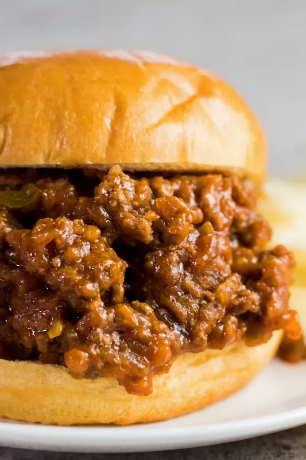 tall closeup image of sloppy joes on bun with light background..
