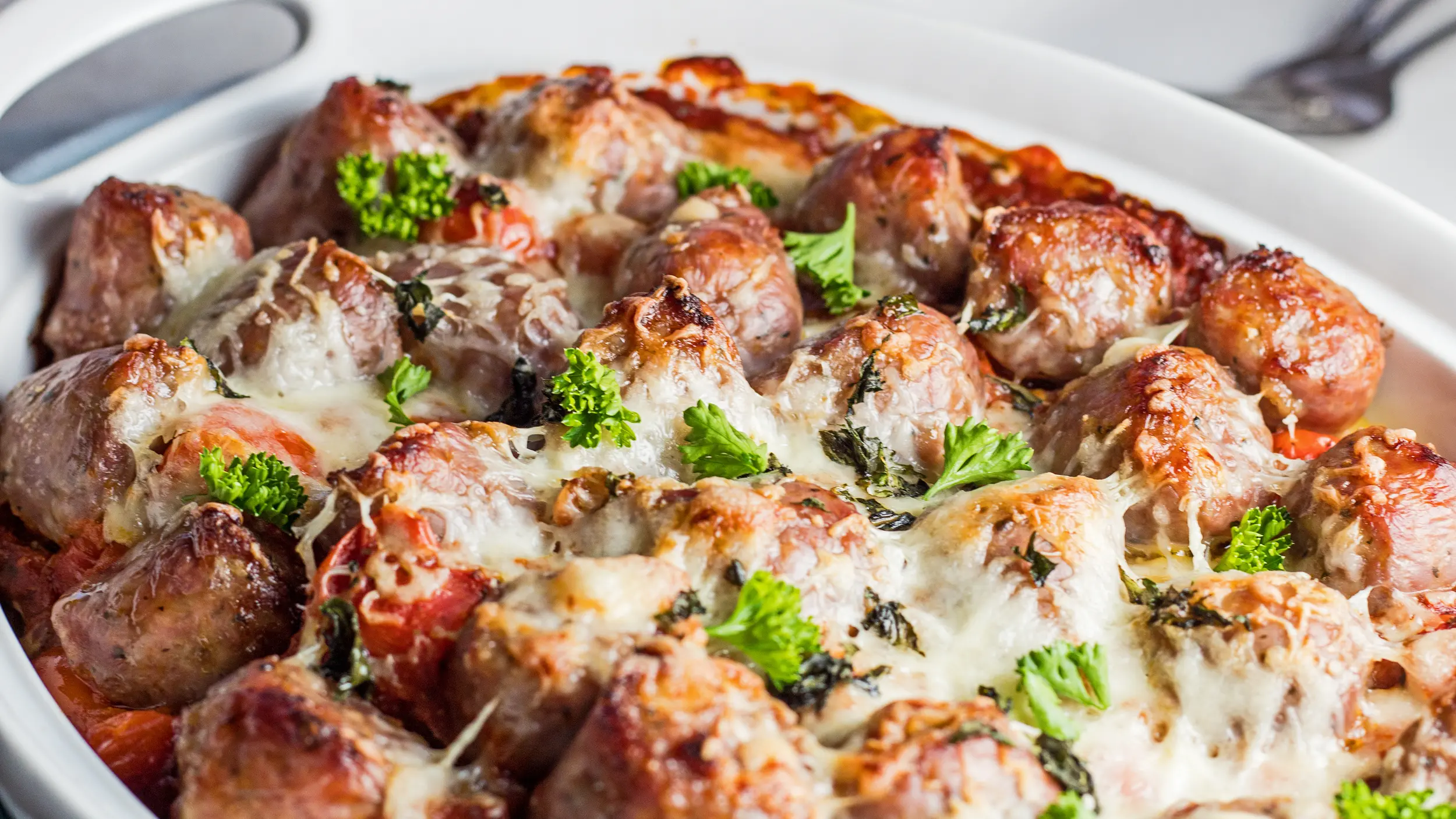 wide overhead image of the Italian Sausage Bake in white casserole dish.