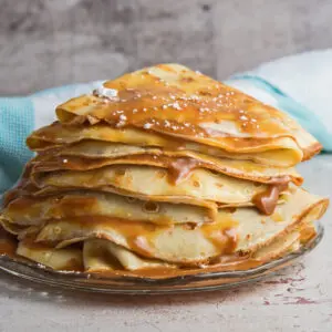 large square straight on image of the folded and stacked panqueques con dulce de leche.