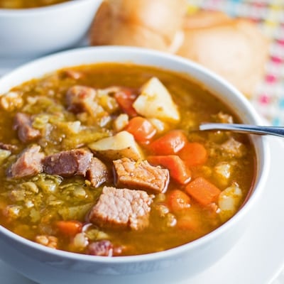 small square angled overhead image of sopa de chicharos served in white bowl.